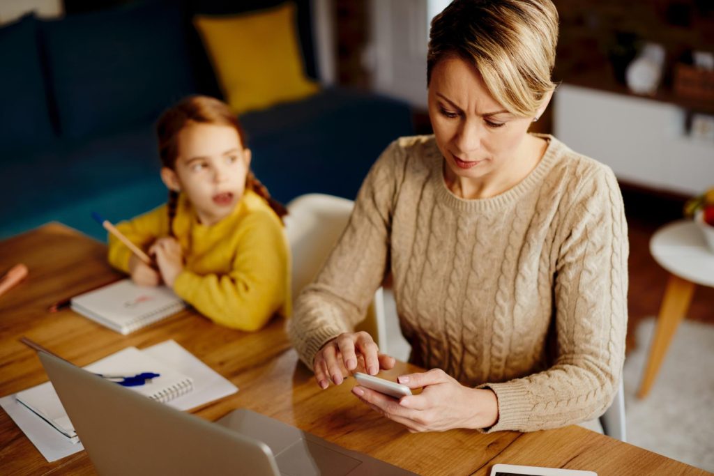 Mid adult mother using smart phone