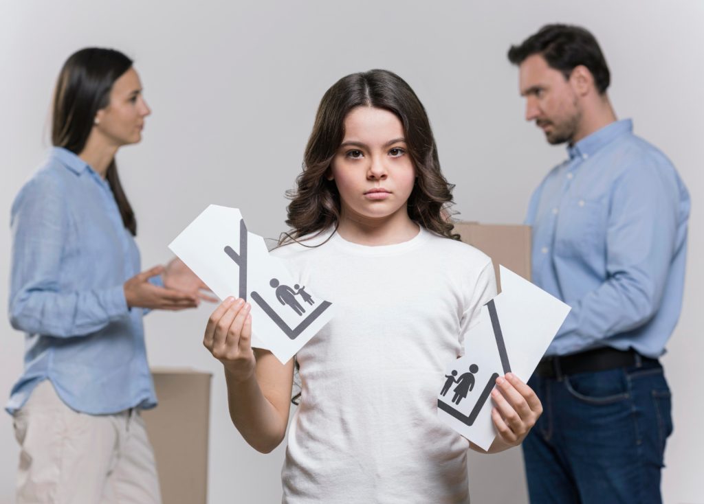 Sad girl with parents arguing behind